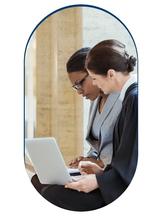 Two judicial officers reviewing a case on a laptop